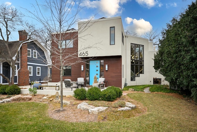 back of house with a yard and a patio