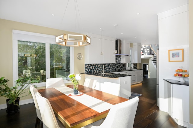 dining space featuring dark wood-type flooring, a chandelier, and sink