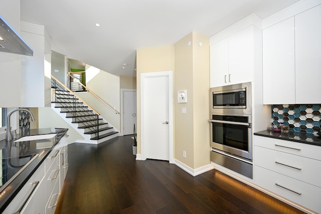 kitchen featuring dark hardwood / wood-style floors, sink, white cabinets, decorative backsplash, and stainless steel appliances