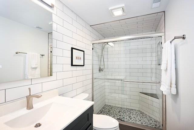 bathroom featuring toilet, an enclosed shower, tile walls, vanity, and backsplash