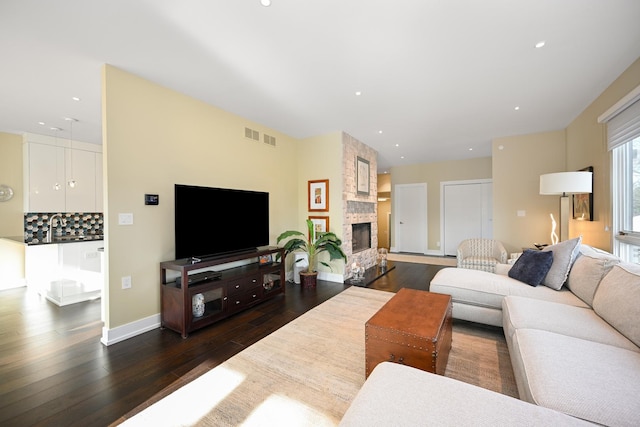 living room with a fireplace and dark hardwood / wood-style flooring