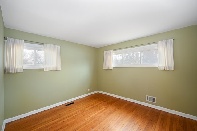 unfurnished room with hardwood / wood-style flooring and a wealth of natural light