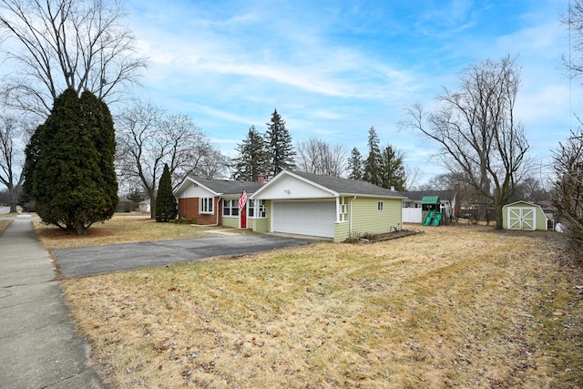 view of front of property with a storage shed, a garage, a front yard, and a playground