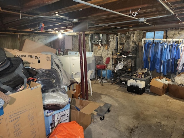 basement featuring washing machine and clothes dryer and electric panel