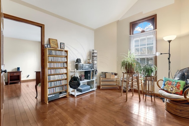 living area with wood-type flooring and vaulted ceiling