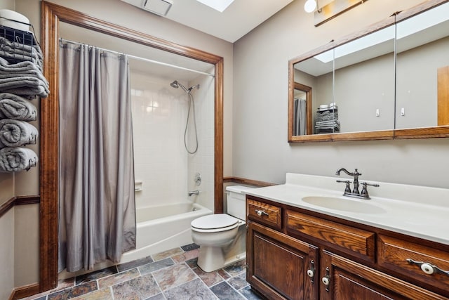 full bathroom with vanity, toilet, shower / bathtub combination with curtain, and a skylight