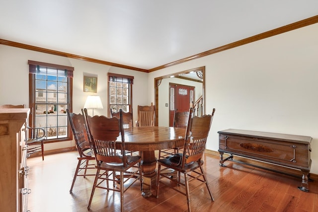 dining space with hardwood / wood-style flooring and crown molding