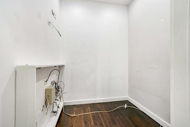 laundry room with dark wood-type flooring