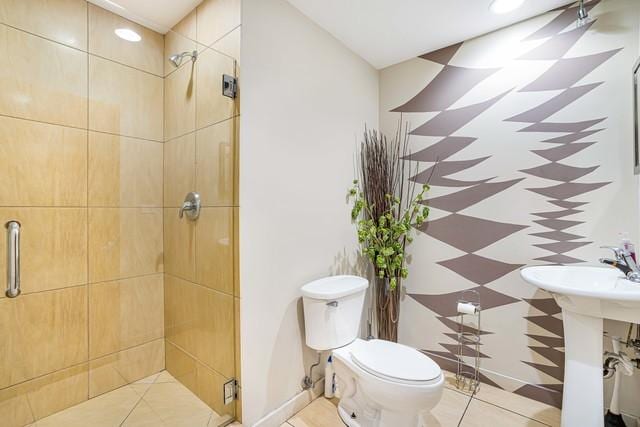 bathroom featuring toilet, sink, and a shower with shower door