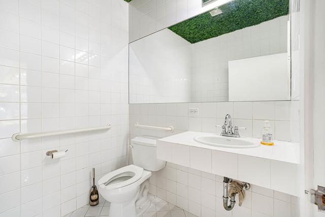 bathroom featuring sink, tile walls, decorative backsplash, and toilet