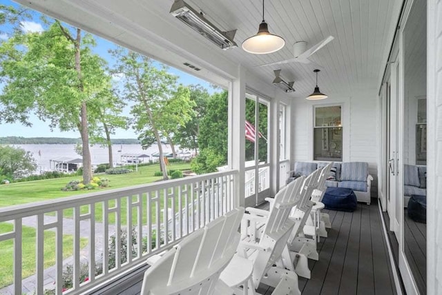 deck featuring a yard, ceiling fan, and a water view