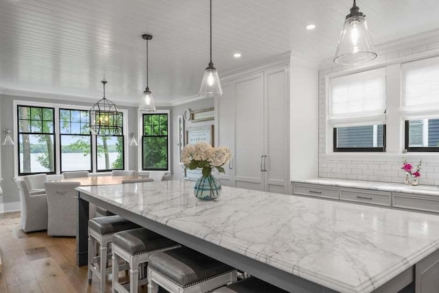 kitchen with pendant lighting, a center island, decorative backsplash, and white cabinets