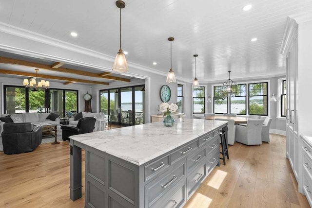 kitchen featuring white cabinetry, a large island, a breakfast bar, and hanging light fixtures