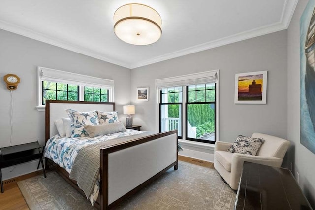 bedroom featuring multiple windows, crown molding, and hardwood / wood-style floors