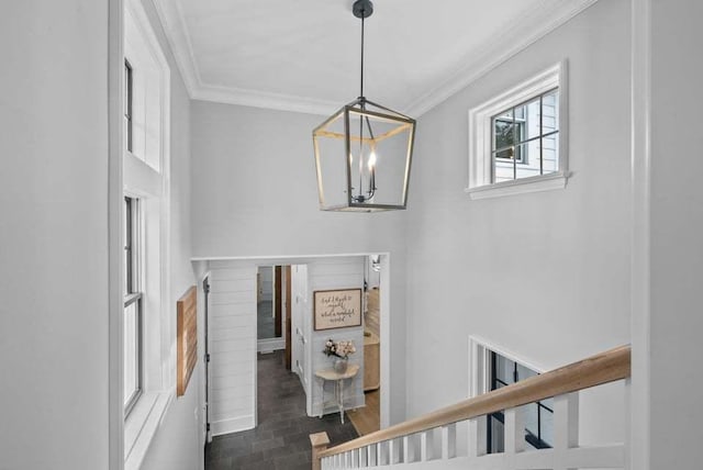 stairway featuring ornamental molding and a notable chandelier