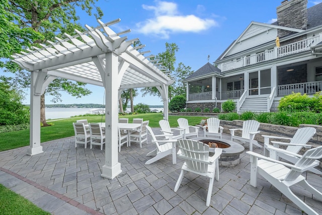 view of patio / terrace featuring a fire pit, a pergola, a water view, a sunroom, and a balcony