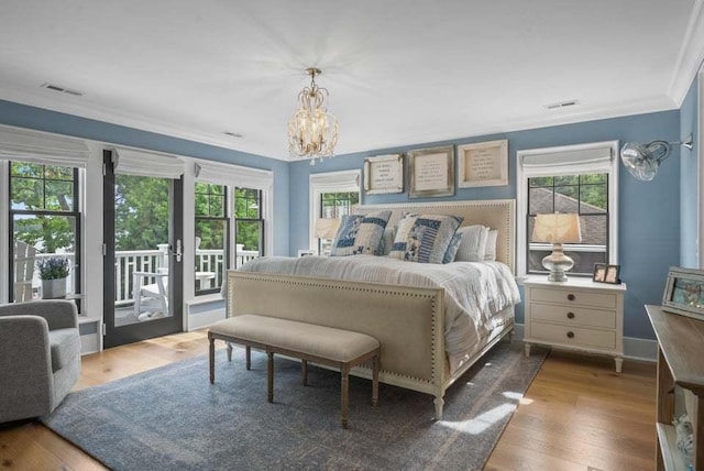 bedroom with multiple windows, hardwood / wood-style floors, and access to exterior