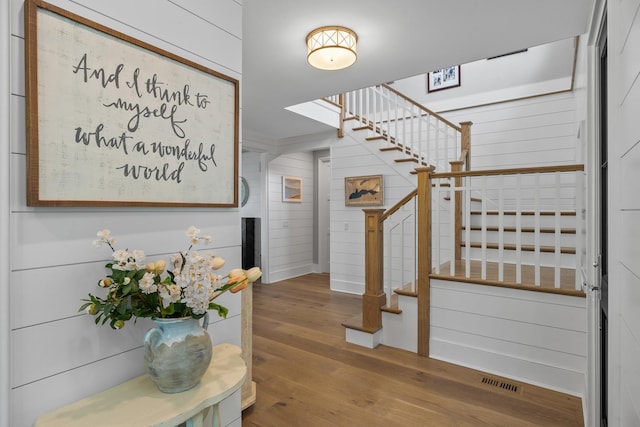 entryway with hardwood / wood-style flooring and wooden walls