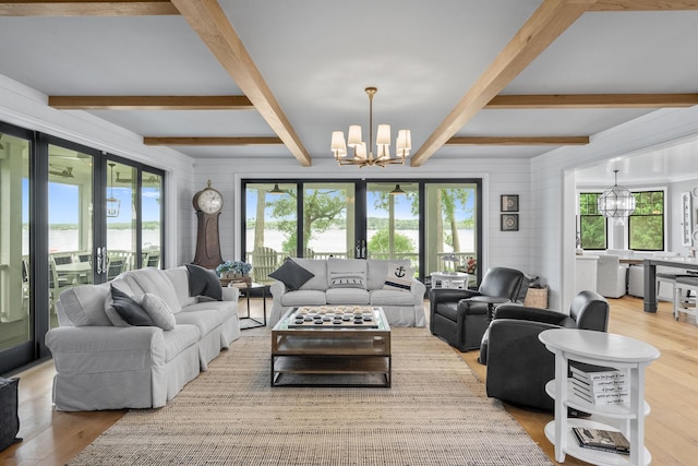 living room featuring a wealth of natural light, an inviting chandelier, and light hardwood / wood-style flooring