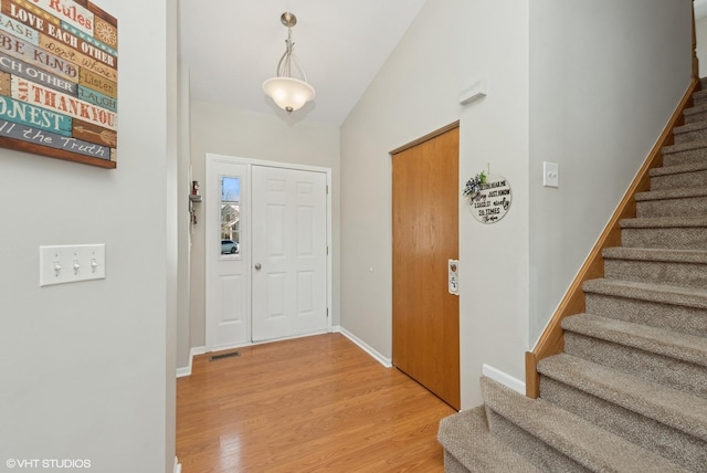 foyer entrance featuring light hardwood / wood-style flooring and lofted ceiling