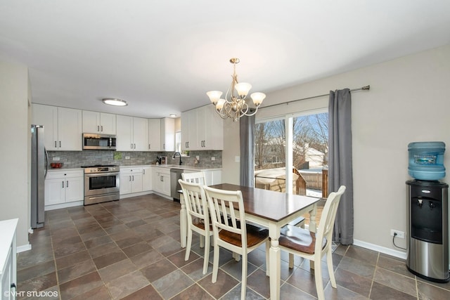 dining area featuring sink and an inviting chandelier