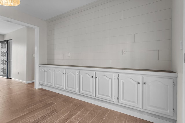 interior space featuring crown molding, wood finished floors, and baseboards