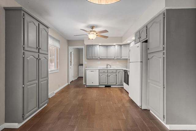 kitchen featuring ceiling fan, white appliances, dark wood-style flooring, gray cabinets, and washer / clothes dryer