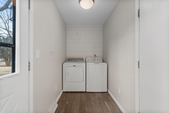 laundry room featuring a wealth of natural light, laundry area, washer and clothes dryer, and wood finished floors