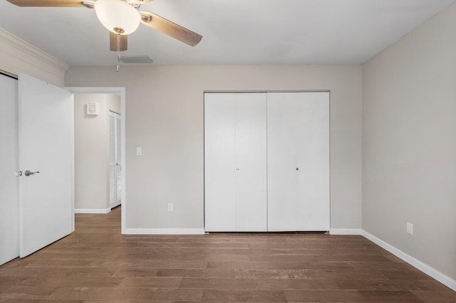 unfurnished bedroom featuring ceiling fan, wood finished floors, visible vents, baseboards, and a closet