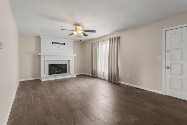 unfurnished living room with a large fireplace, visible vents, a ceiling fan, baseboards, and dark wood-style floors