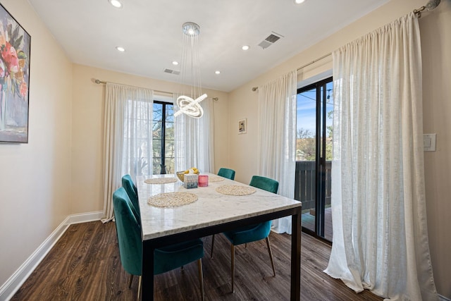 dining room with dark wood-type flooring and a wealth of natural light