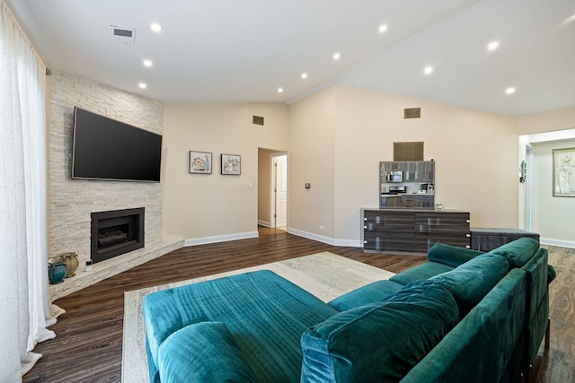 living room with a fireplace, dark hardwood / wood-style floors, and vaulted ceiling