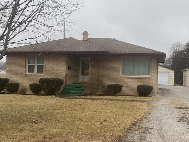 view of front facade featuring a garage, an outdoor structure, and a front yard