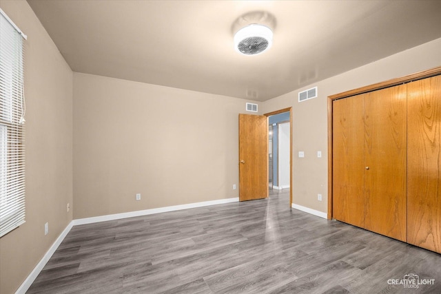 unfurnished bedroom featuring wood-type flooring and a closet