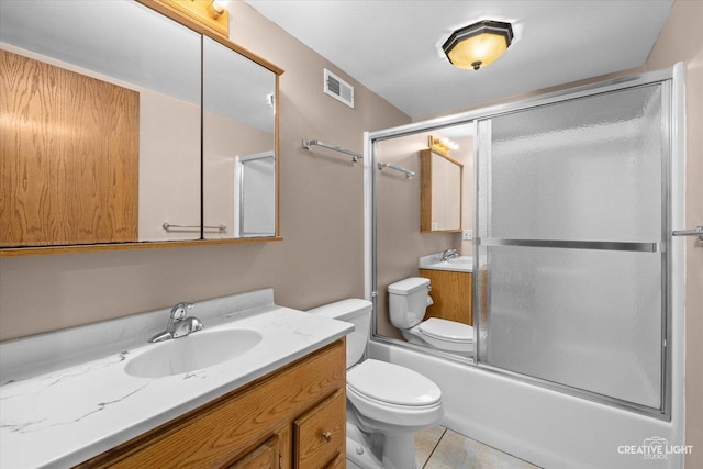 full bathroom featuring vanity, bath / shower combo with glass door, tile patterned floors, and toilet