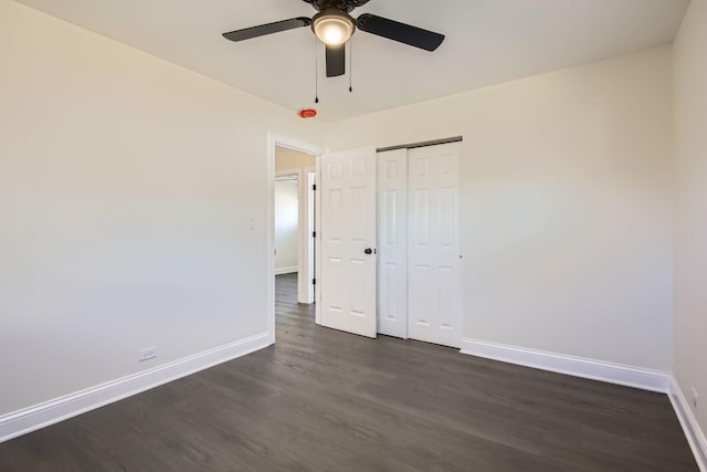 unfurnished bedroom with dark hardwood / wood-style flooring, a closet, and ceiling fan