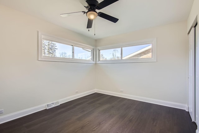 unfurnished room with dark wood-type flooring, ceiling fan, and a healthy amount of sunlight