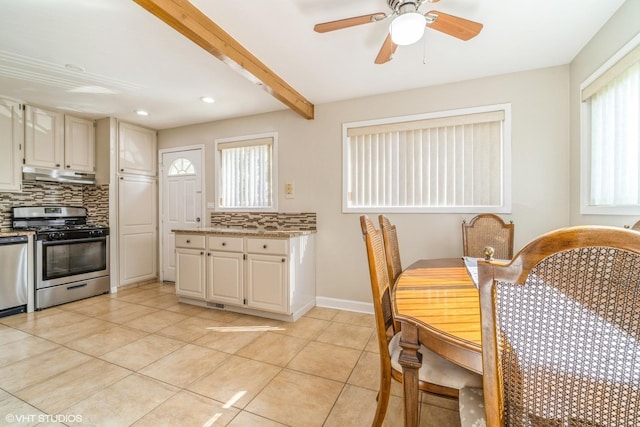 kitchen featuring tasteful backsplash, appliances with stainless steel finishes, beam ceiling, and light tile patterned floors