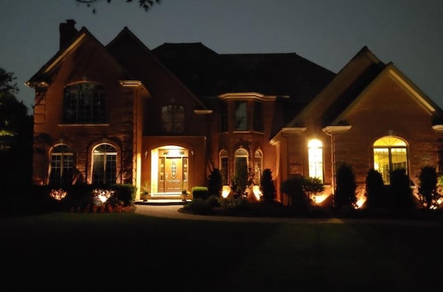 french country inspired facade featuring a chimney