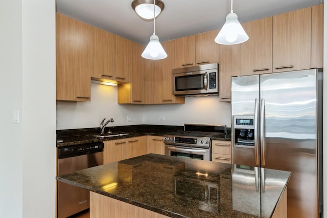 kitchen with appliances with stainless steel finishes, decorative light fixtures, sink, and dark stone countertops