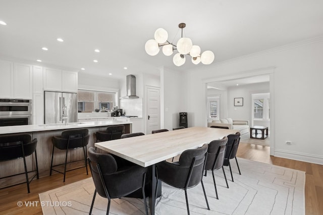2645 Prairie Ave, Evanston, IL 60201 - dining room with recessed lighting, a chandelier, light wood-style flooring, crown molding, and baseboards