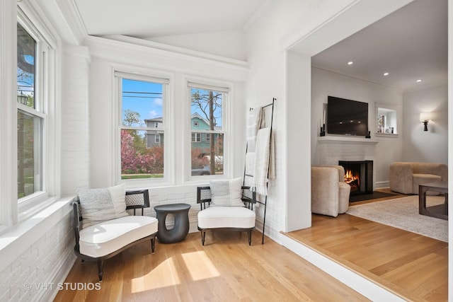 2645 Prairie Ave, Evanston, IL 60201 - sitting room featuring a lit fireplace, vaulted ceiling, ornamental molding, and wood finished floors