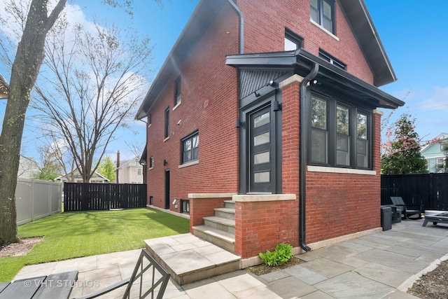 2645 Prairie Ave, Evanston, IL 60201 - view of property exterior featuring brick siding, a lawn, and a fenced backyard