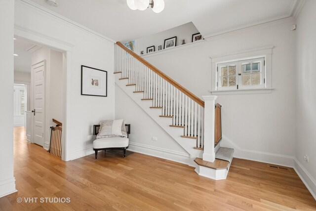 2645 Prairie Ave, Evanston, IL 60201 - stairs featuring ornamental molding, baseboards, visible vents, and wood finished floors