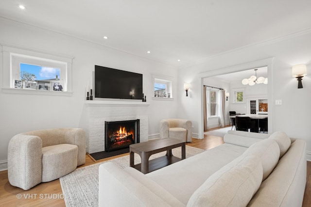 2645 Prairie Ave, Evanston, IL 60201 - living area featuring ornamental molding, light wood-type flooring, recessed lighting, a fireplace, and a notable chandelier