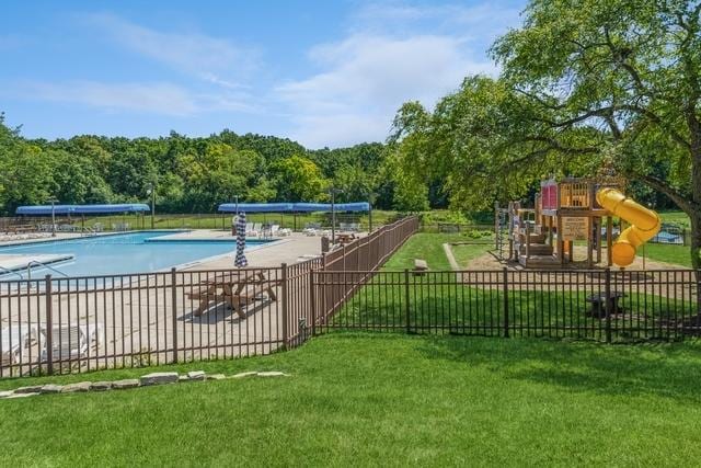 pool featuring fence, playground community, and a yard