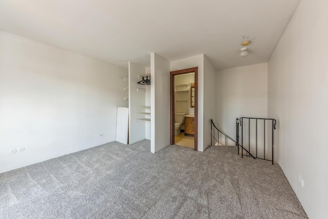 unfurnished bedroom featuring carpet floors and connected bathroom