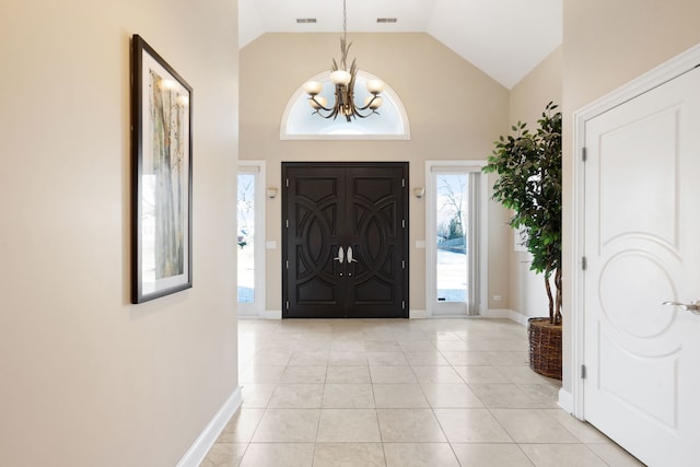 tiled foyer with an inviting chandelier and high vaulted ceiling