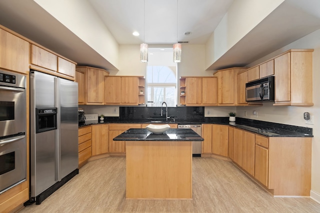 kitchen with stainless steel appliances, a center island, sink, and dark stone counters