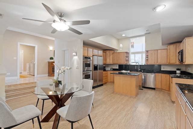 kitchen with light brown cabinetry, light hardwood / wood-style flooring, stainless steel appliances, and a kitchen island